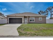 Charming single-story home featuring a well-manicured lawn and attached one-car garage at 702 Pelican Ct, Kissimmee, FL 34759