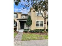 Inviting two-story townhome featuring well-maintained landscaping and neutral color palette at 7681 Fordson Ln, Windermere, FL 34786