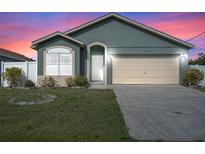 Charming one-story home featuring a two-car garage and well-maintained front lawn at dusk at 8519 Rainbow Ave, Orlando, FL 32825