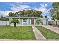 Charming one-story home with green paint, meticulous landscaping, and a welcoming walkway at 1161 Ramble Ave, Deltona, FL 32725
