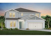 Charming two-story home with a two-car garage, teal door, manicured lawn and lush landscaping at 3110 Norcott Dr, Davenport, FL 33837