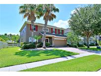 Charming two-story home featuring a well-maintained lawn, brick driveway, and lush landscaping at 535 Belle Fern Ct, Ocoee, FL 34761