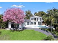 Stunning modern home with a pristine pool, lush green lawn, and beautiful landscaping at 641 Lake Catherine Dr, Maitland, FL 32751
