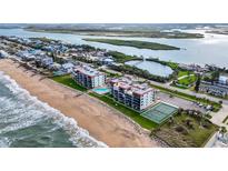 Beautiful aerial view of beachside condos with a pool and tennis court near the ocean at 6727 Turtlemound Rd # 417, New Smyrna Beach, FL 32169