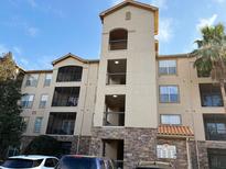 Multi-story condo building with balconies and lush landscaping on a sunny day at 8000 Tuscany Way # 4405, Davenport, FL 33896