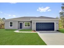 Charming single-story home featuring a blue garage door, fresh lawn, and a modern gray exterior at 142 Guava Pass, Ocklawaha, FL 32179