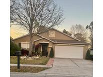 Charming single-story home featuring a well-manicured lawn and attached two car garage at 15688 Galbi Dr, Orlando, FL 32828