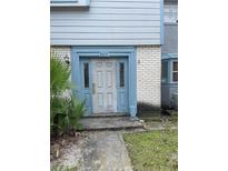 Charming townhome entrance with blue door frame and weathered white front door, palm on left at 3071 George Mason Ave # A, Winter Park, FL 32792