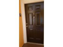 A close-up of the solid, dark brown front door of the residence with the unit number clearly visible at 5455 Vineland Rd # 3303, Orlando, FL 32811