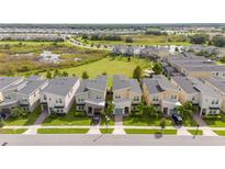 Beautiful aerial view of modern homes with lush green lawns and a serene lake in the background at 831 Drop Shot Dr, Davenport, FL 33896