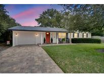Charming single story home with a bright orange front door and manicured lawn at 301 Forest Ave, Altamonte Springs, FL 32701