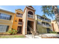 Exterior view of the building featuring multiple levels, a stairway, and yellow and green siding at 5005 City St # 1315, Orlando, FL 32839