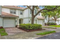 Charming townhome with brick driveway, one-car garage, well maintained landscaping, and tile roof at 7159 Cadiz Blvd, Orlando, FL 32819
