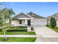 Charming single-story home with a well-manicured lawn, decorative shrubbery, and a welcoming two-car garage at 9542 Beautiful Way, Winter Garden, FL 34787