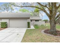 Charming single-story home with a well-maintained lawn, mature trees, and attached garage at 169 Fallwood St, Fern Park, FL 32730