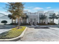 Modern townhome with a two-story facade, stone accents, lush landscaping, and convenient parking spaces at 17442 Hidden Forest Dr, Clermont, FL 34714