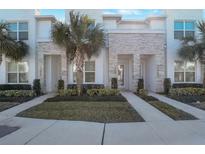 Contemporary townhome with stacked stone accents, manicured landscaping, and bright, modern facade at 17442 Hidden Forest Dr, Clermont, FL 34714