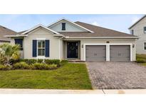 Charming home with a well-manicured lawn and a two-car garage with a brick paved driveway at 18405 Mowry Ct, Orlando, FL 32827