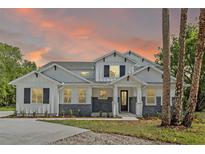 Beautiful two-story home featuring stone accents, a modern design, and manicured landscaping at 2650 Howard Ave, Oviedo, FL 32765