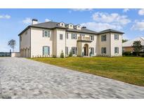 Stunning home with a beautiful lawn, long driveway, and lovely architectural details at 30215 Island Club Dr, Deer Island, FL 32778