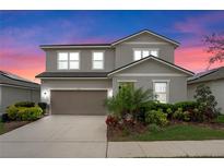 Charming two-story home features a well-maintained yard, neutral exterior paint and attached two car garage at 580 Buchannan Dr, Davenport, FL 33837