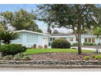 Charming single-story home boasts a well-manicured lawn, mature trees, and stylish mid-century modern architectural features at 625 Worthington Dr, Winter Park, FL 32789