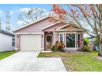 Charming single-story home with a well-maintained lawn, an attached garage, and beautiful landscaping at 7824 Sagebrush Pl, Orlando, FL 32822
