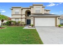 Inviting two-story home with well-manicured lawn, two car garage, and classic architectural details at 12543 Waterhaven Cir, Orlando, FL 32828