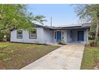 Charming single-story house featuring a gray exterior, solar panels, and a well-maintained front yard at 1834 Willie Mays Pkwy, Orlando, FL 32811