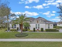 Charming single-story home with a well-manicured lawn and lush tropical landscaping at 31746 Red Tail Blvd, Sorrento, FL 32776