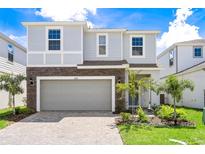 Beautiful two-story home with stone accents, well-manicured lawn, and a spacious two-car garage at 3432 Lilac Way, Davenport, FL 33897