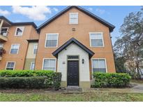 Charming condo featuring a well-manicured lawn with lush bushes and a welcoming, covered entryway at 6071 Westgate Dr # 312, Orlando, FL 32835