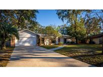 Charming single-Gathering home with a well-manicured lawn, mature trees, and an attached two-car garage at 109 Crestwood Dr, Longwood, FL 32779