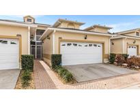 Well maintained townhome featuring a two-car garage and nicely landscaped front yard at 13221 Fountainbleau Dr, Clermont, FL 34711