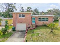 Charming single-story brick home with a well-maintained lawn, garage, and inviting blue front door at 256 Morningside Ave, Daytona Beach, FL 32118