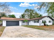 Charming single-story home features a gray garage door, white exterior, and well-manicured lawn at 921 W Lake Brantley Rd, Altamonte Springs, FL 32714