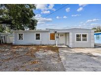 Modest single-story home featuring a light-colored exterior and a small front yard at 1408 N Pine Hills Rd, Orlando, FL 32808