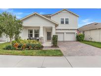 Lovely two-story home with a welcoming front porch and a brick paver driveway, complemented by lush landscaping at 1472 Rushing Rapids Way, Winter Springs, FL 32708