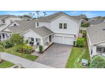 Beautiful two-story home featuring a covered porch with stone accents, a brick driveway, and a two-car garage at 1472 Rushing Rapids Way, Winter Springs, FL 32708