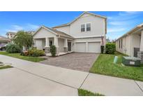 Inviting two-story home with a brick driveway, two-car garage, and a landscaped front yard at 1472 Rushing Rapids Way, Winter Springs, FL 32708