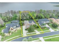 Stunning lakefront property boasts lush landscaping, mature trees, and a private backyard oasis at 210 Torcaso Ct, Winter Springs, FL 32708