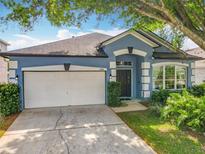 Charming one-story blue home with a two-car garage and nicely manicured lawn, offering great curb appeal at 4020 Shawn Cir, Orlando, FL 32826