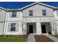 Charming two-story townhouse with neutral siding, light blue shutters and well-maintained landscaping at 4058 Lana Avenue, Davenport, FL 33897