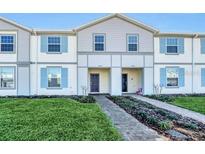 Charming townhome exterior with light blue shutters and well-manicured lawn at 4058 Lana Avenue, Davenport, FL 33897