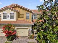 Charming two-story home featuring a brick driveway, tile roof, and an attached two-car garage at 5150 Fiorella Ln, Sanford, FL 32771