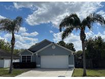 Charming single-story home with an attached two-car garage, palm trees, and a well-maintained front yard at 636 Bohannon Blvd, Orlando, FL 32824