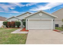 Charming single-story home with a two-car garage, manicured lawn, and landscaped front yard at 11223 Huxley Ave, Orlando, FL 32837