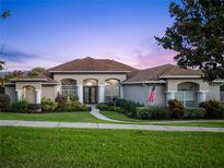 Charming one-story home with a manicured front yard, lush landscaping and walkway to a covered front porch at 16344 Magnolia Bluff Dr, Montverde, FL 34756