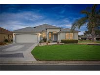 Charming single-story home with a manicured lawn and a well-maintained landscape at 1700 Norfolk Ave, The Villages, FL 32162