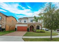 Charming two-story home featuring stone accents, a brick driveway, and a well-manicured lawn at 1077 Fountain Coin Loop, Orlando, FL 32828